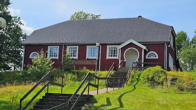 Ett rödmålat hus med grått tak och texten bygdegård på fasaden