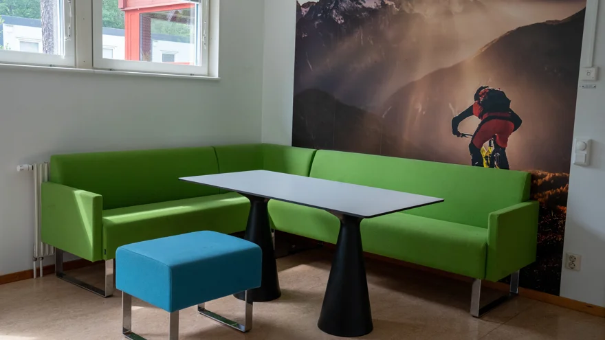 Soffa och pall runt ett bord med stor mountainbike-tavla i bakgrunden
